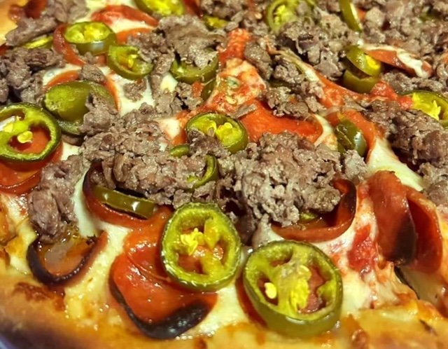 Pizza with ground meat, pepperoni, jalapeños